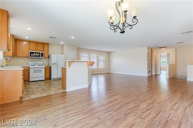 11577 Vesuvio Ct, Las Vegas, NV 89183 - kitchen with white appliances, open floor plan, light countertops, light wood-style flooring, and recessed lighting