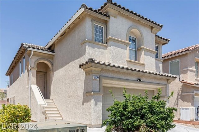 11577 Vesuvio Ct, Las Vegas, NV 89183 - mediterranean / spanish home with an attached garage, a tile roof, and stucco siding