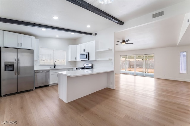 3915 Delling Ct, Las Vegas, NV 89104 - kitchen featuring appliances with stainless steel finishes, open shelves, beam ceiling, a peninsula, and light countertops