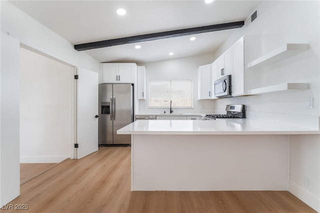 3915 Delling Ct, Las Vegas, NV 89104 - kitchen with stainless steel appliances, open shelves, a peninsula, beamed ceiling, and light wood-style flooring
