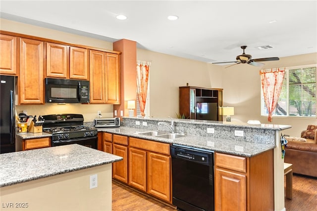 8316 Mokena Ave, Las Vegas, NV 89178 - kitchen with black appliances, open floor plan, a peninsula, light wood-type flooring, and recessed lighting