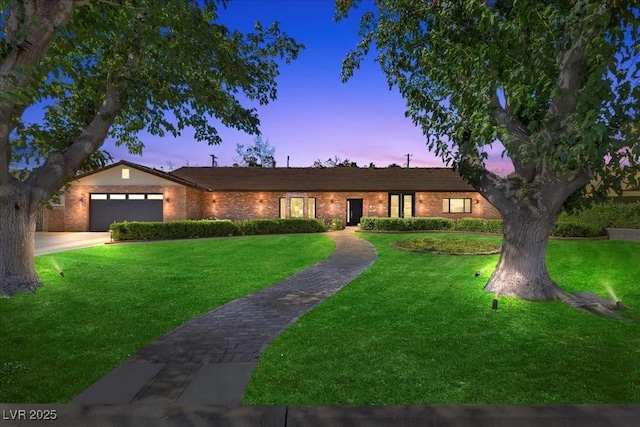 3104 Conners Dr, Las Vegas, NV 89107 - ranch-style house featuring a front lawn, a garage, brick siding, and driveway