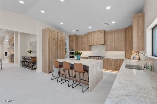 3104 Conners Dr, Las Vegas, NV 89107 - kitchen featuring modern cabinets, a kitchen island, a breakfast bar, backsplash, and stainless steel appliances