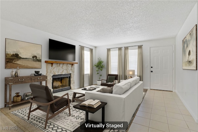 3455 Erva St Unit 112, Las Vegas, NV 89117 - living room with a textured ceiling, a stone fireplace, and light tile patterned floors