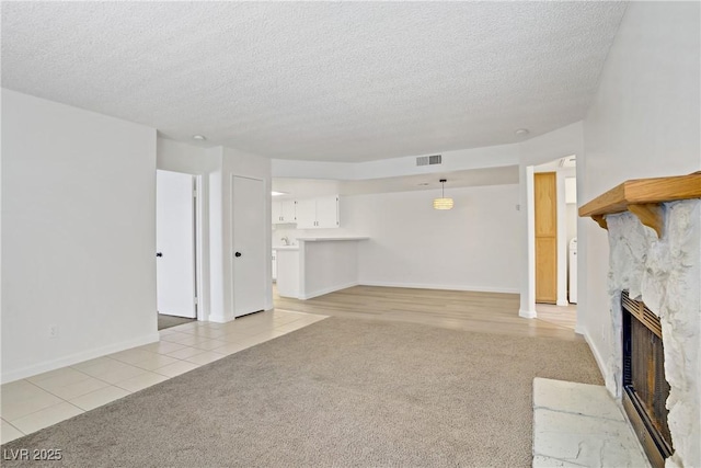 3455 Erva St Unit 112, Las Vegas, NV 89117 - unfurnished living room with light colored carpet, a fireplace, a textured ceiling, and light tile patterned floors