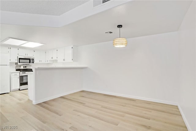 3455 Erva St Unit 112, Las Vegas, NV 89117 - kitchen featuring appliances with stainless steel finishes, light wood finished floors, light countertops, and white cabinets