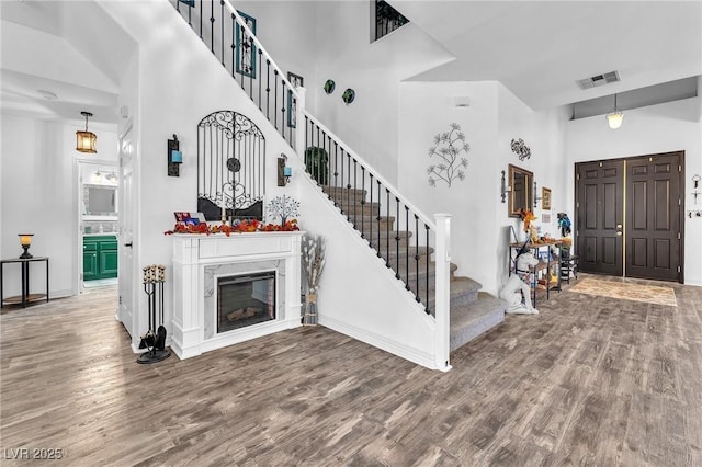 10654 Sidlaw Hills Ct, Las Vegas, NV 89141 - entrance foyer featuring a high ceiling, wood finished floors, stairway, and a glass covered fireplace