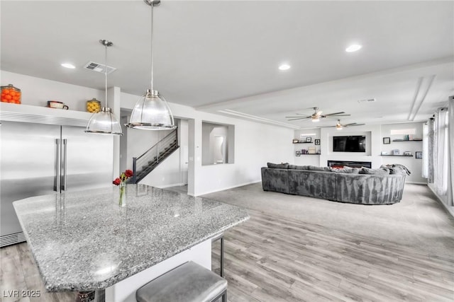 5976 Rockway Glen Ave, Las Vegas, NV 89141 - kitchen with built in fridge, ceiling fan, wood finished floors, recessed lighting, and stone countertops