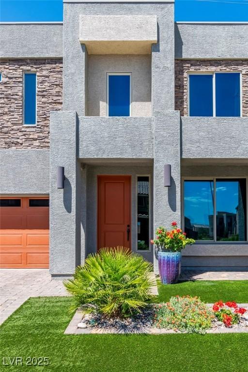 5976 Rockway Glen Ave, Las Vegas, NV 89141 - view of front facade with stucco siding, a garage, and stone siding