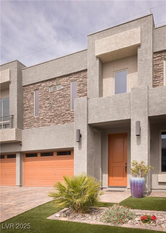 5976 Rockway Glen Ave, Las Vegas, NV 89141 - view of front of property featuring a garage, decorative driveway, stucco siding, and stone siding