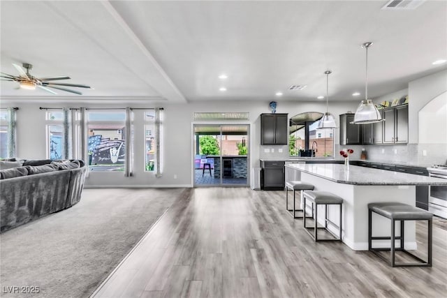 5976 Rockway Glen Ave, Las Vegas, NV 89141 - kitchen featuring open floor plan, a breakfast bar area, recessed lighting, a ceiling fan, and light wood-style floors
