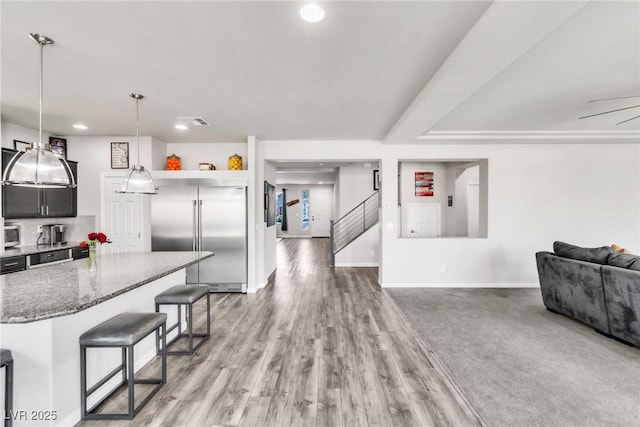 5976 Rockway Glen Ave, Las Vegas, NV 89141 - kitchen featuring stainless steel built in fridge, a breakfast bar area, stone counters, recessed lighting, and open floor plan