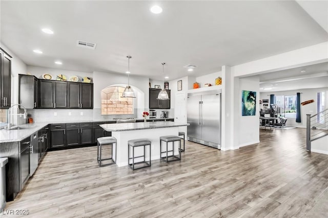 5976 Rockway Glen Ave, Las Vegas, NV 89141 - kitchen featuring built in fridge, recessed lighting, a kitchen island, a breakfast bar area, and tasteful backsplash