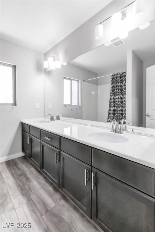 5976 Rockway Glen Ave, Las Vegas, NV 89141 - bathroom with double vanity, curtained shower, and wood finished floors
