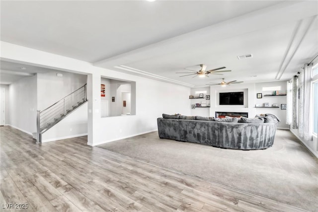 5976 Rockway Glen Ave, Las Vegas, NV 89141 - living room featuring a ceiling fan, stairs, wood finished floors, and a glass covered fireplace