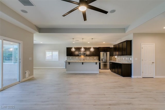 6085 Ryan Ranch Ave, Las Vegas, NV 89130 - kitchen with stainless steel appliances, open floor plan, tasteful backsplash, light wood finished floors, and recessed lighting