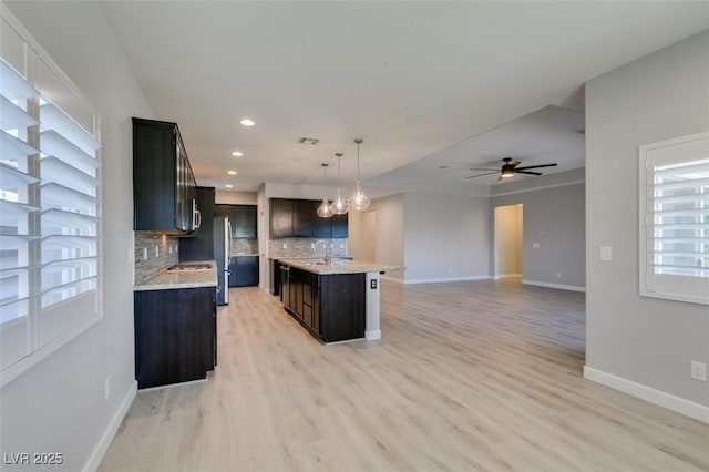 6085 Ryan Ranch Ave, Las Vegas, NV 89130 - kitchen featuring decorative backsplash, light wood finished floors, ceiling fan, decorative light fixtures, and recessed lighting