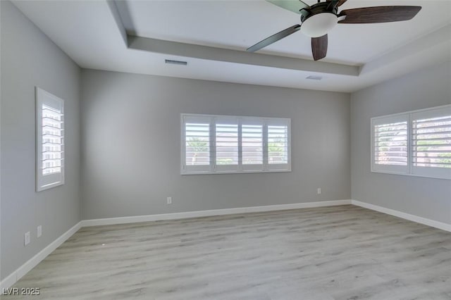 6085 Ryan Ranch Ave, Las Vegas, NV 89130 - empty room featuring healthy amount of natural light, light wood-style flooring, a tray ceiling, and ceiling fan