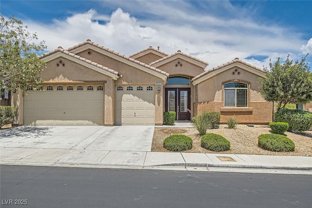 9252 Oxbow Lake Ave, Las Vegas, NV 89149 - mediterranean / spanish house featuring an attached garage, driveway, stucco siding, and french doors