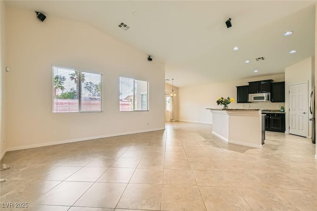 9252 Oxbow Lake Ave, Las Vegas, NV 89149 - unfurnished living room featuring vaulted ceiling, light tile patterned flooring, and recessed lighting