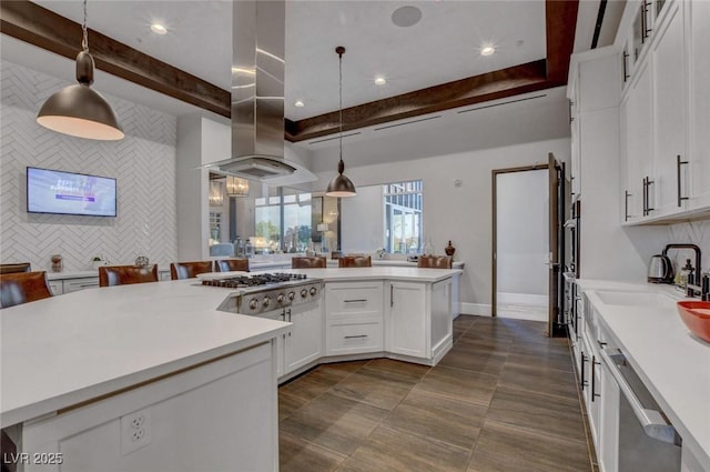 794 Sunny Sagebrush St, Henderson, NV 89011 - kitchen with stainless steel gas stovetop, island range hood, light countertops, white cabinetry, and decorative light fixtures