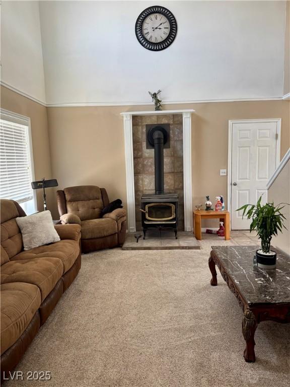 2345 Iron Dr, Ely, NV 89301 - living room featuring carpet, a wood stove, and a towering ceiling
