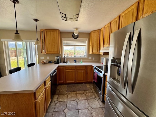 2345 Iron Dr, Ely, NV 89301 - kitchen with stainless steel appliances, a peninsula, light countertops, a textured ceiling, and pendant lighting