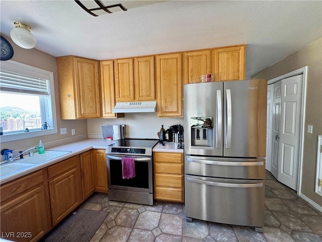 2345 Iron Dr, Ely, NV 89301 - kitchen featuring stainless steel appliances, under cabinet range hood, light countertops, stone finish floors, and a textured ceiling
