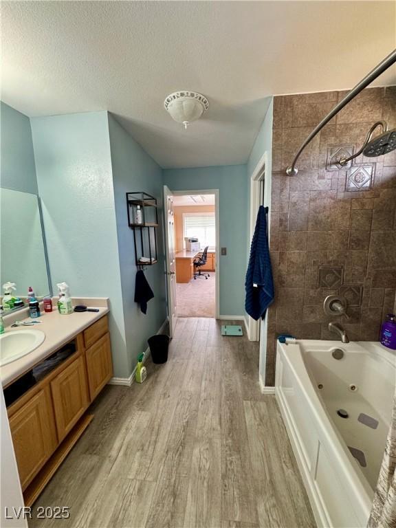 2345 Iron Dr, Ely, NV 89301 - full bathroom with wood finished floors, vanity, a combined bath / shower with jetted tub, and a textured ceiling