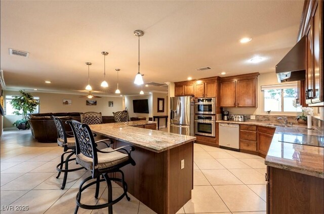 3597 Cochise Ln, Las Vegas, NV 89169 - kitchen with stainless steel appliances, open floor plan, wall chimney exhaust hood, light tile patterned flooring, and a breakfast bar