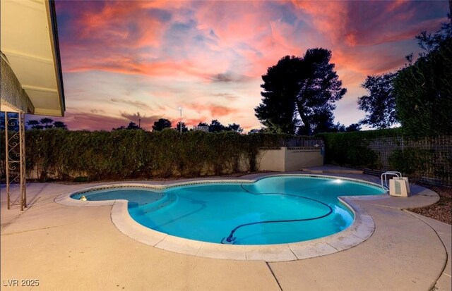 3597 Cochise Ln, Las Vegas, NV 89169 - pool at dusk featuring a fenced backyard and a patio