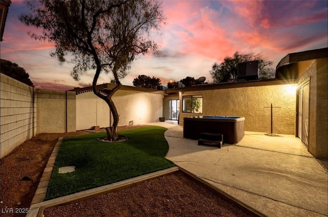 3597 Cochise Ln, Las Vegas, NV 89169 - yard at dusk featuring a hot tub, a patio area, and a fenced backyard