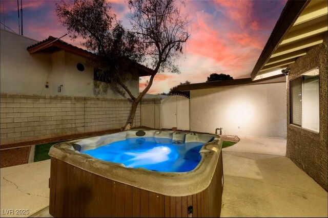 3597 Cochise Ln, Las Vegas, NV 89169 - pool at dusk featuring a hot tub, a fenced backyard, and a patio