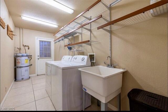 3597 Cochise Ln, Las Vegas, NV 89169 - laundry room featuring strapped water heater, washing machine and dryer, and light tile patterned floors