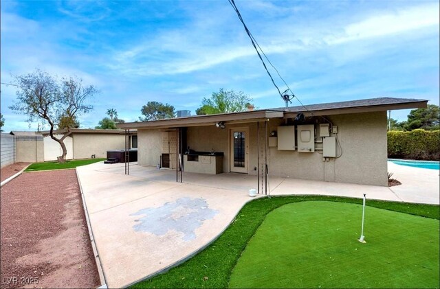 3597 Cochise Ln, Las Vegas, NV 89169 - back of house with stucco siding, a patio area, and an area to practice putting