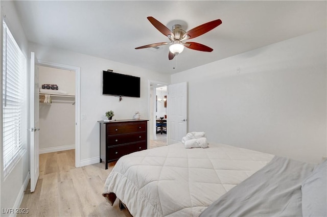 4200 S Valley View Blvd Unit 2009, Las Vegas, NV 89103 - bedroom featuring light wood finished floors, a walk in closet, multiple windows, and ceiling fan
