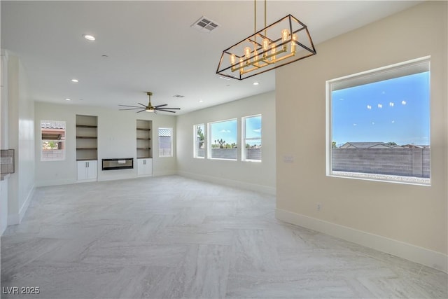 1525 Heights Dr, Logandale, NV 89021 - unfurnished living room featuring ceiling fan, a chandelier, a glass covered fireplace, recessed lighting, and built in shelves