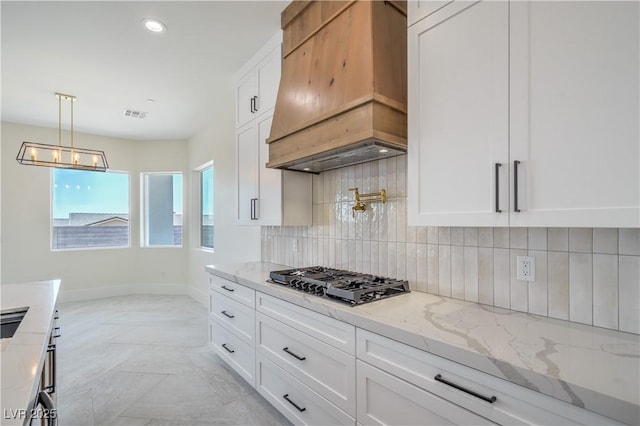 1525 Heights Dr, Logandale, NV 89021 - kitchen with custom range hood, stainless steel gas stovetop, white cabinets, light stone counters, and recessed lighting
