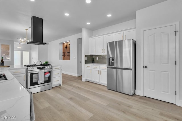 10200 Wood Work Ln, Las Vegas, NV 89135 - kitchen featuring appliances with stainless steel finishes, island exhaust hood, white cabinets, light stone counters, and light wood-type flooring