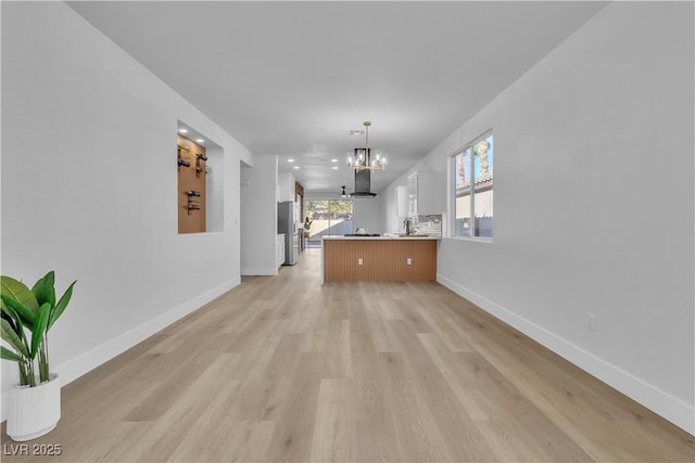 10200 Wood Work Ln, Las Vegas, NV 89135 - unfurnished living room featuring a chandelier and light wood finished floors