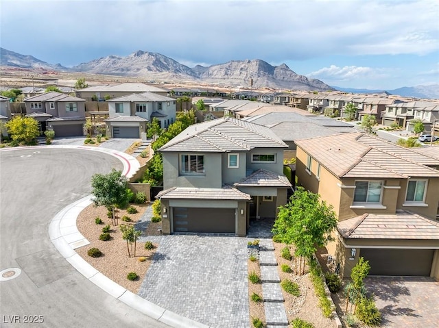 12426 Alpenglow Ct, Las Vegas, NV 89138 - view of front facade featuring a residential view, stucco siding, a garage, a mountain view, and driveway