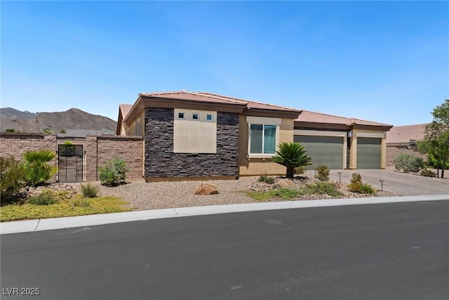 4317 Velvet Ridge Ct, Las Vegas, NV 89129 - prairie-style house featuring a garage, stucco siding, stone siding, driveway, and a mountain view