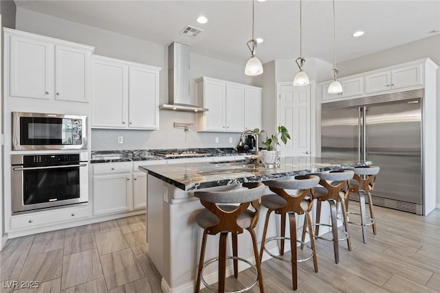 4317 Velvet Ridge Ct, Las Vegas, NV 89129 - kitchen with appliances with stainless steel finishes, wall chimney exhaust hood, white cabinets, dark stone countertops, and recessed lighting