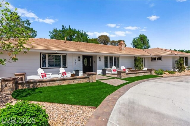 3108 Sonia Dr, Las Vegas, NV 89107 - view of front facade featuring a porch, a chimney, a front lawn, and a tile roof