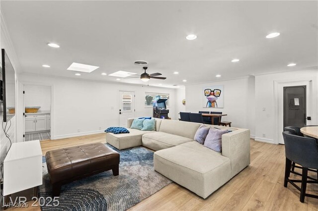 3108 Sonia Dr, Las Vegas, NV 89107 - living room with ceiling fan, light wood-type flooring, recessed lighting, ornamental molding, and a skylight