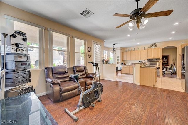 3873 Palm Island Ct, Las Vegas, NV 89147 - living area with arched walkways, ceiling fan, light wood-style floors, and recessed lighting