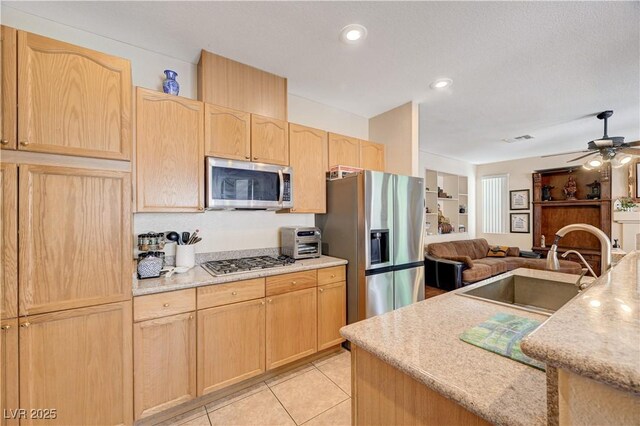 3873 Palm Island Ct, Las Vegas, NV 89147 - kitchen featuring appliances with stainless steel finishes, light brown cabinetry, open floor plan, light countertops, and a ceiling fan