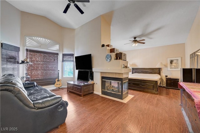 3873 Palm Island Ct, Las Vegas, NV 89147 - living area with ceiling fan, wood finished floors, a tiled fireplace, and lofted ceiling