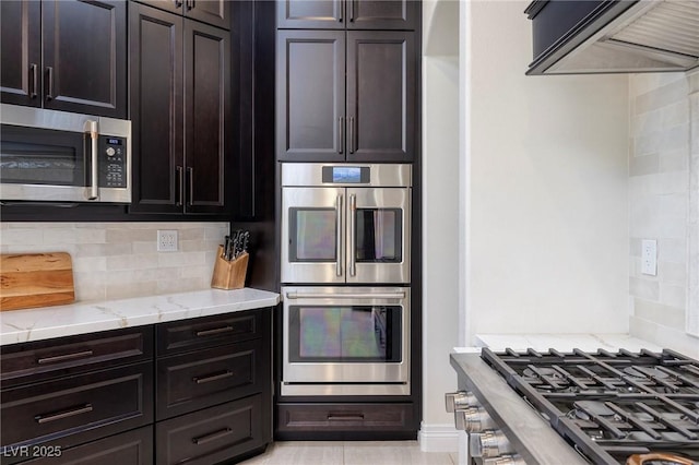 8290 Gagnier Blvd, Las Vegas, NV 89113 - kitchen featuring appliances with stainless steel finishes, exhaust hood, light stone counters, and decorative backsplash