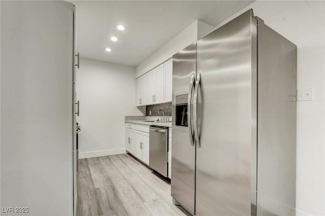 4432 Ash Ave, Las Vegas, NV 89110 - kitchen with appliances with stainless steel finishes, white cabinets, light countertops, light wood-type flooring, and recessed lighting